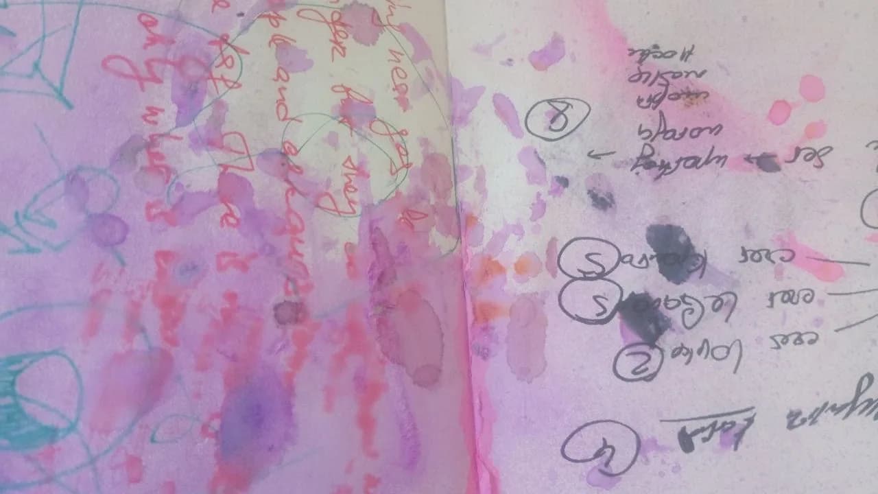 An original sketchbook spread with pink and purple stains, overlapping handwriting and small diagrams on textured paper.