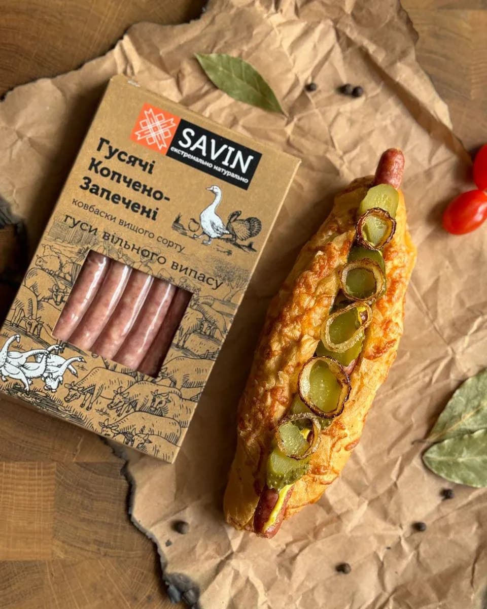 Savin goose-sausage packaging with engraved bird illustrations beside a hot dog.