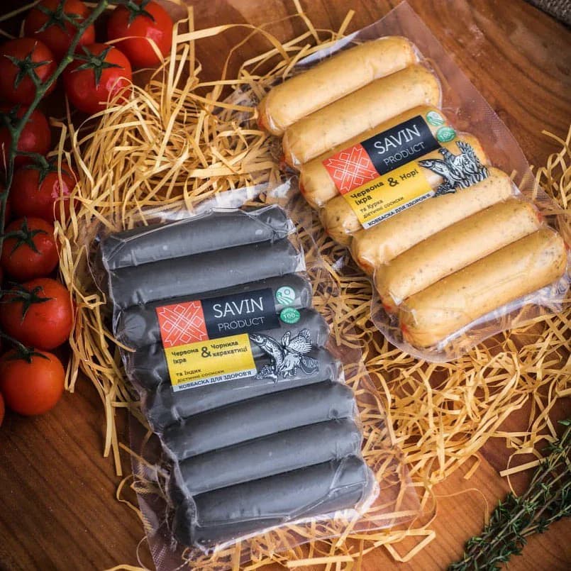 Dark and pale specialty sausages in branded packs with bird illustrations and yellow labels.